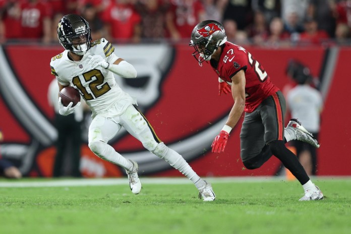 New Orleans Saints wide receiver Chris Olave (12) is pursued by Tampa Bay Buccaneers cornerback Zyon McCollum (27) during the fourth quarter at Raymond James Stadium in Tampa, Florida, on December 5, 2022.