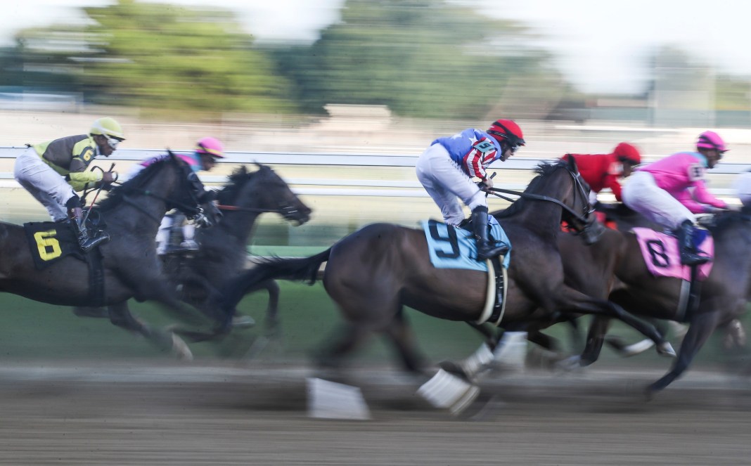 Horses and jockeys speed around the first turn during a race at Twilight Thursday for the 2023 opening of the Fall Meet at Churchill Downs on September 14, 2023.
