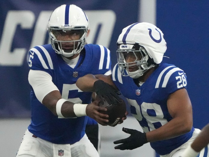 Indianapolis Colts quarterback Anthony Richardson (5) hands the ball off to running back Jonathan Taylor (28) during a preseason game at Lucas Oil Stadium in Indianapolis on August 11, 2024.