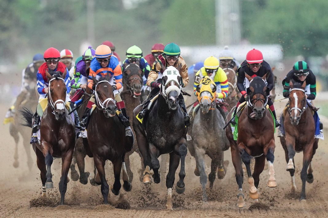 The field of 20 for the 2024 Kentucky Derby enters the first turn during the 150th Run For the Roses at Churchill Downs on Saturday, May 4, 2024, in Louisville, Kentucky. At far right is the eventual winner, Mystik Dan, ridden by Brian J. Hernandez.
