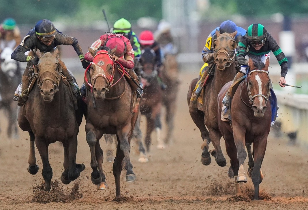 Near the finish line, jockey Tyler Gaffalione (left) and Forever Young's jockey Ryusei Sakai crowd after the two horses bump as Mystik Dan with jockey Brian J. Hernandez (right) wins the 2024 Kentucky Derby at Churchill Downs on May 4, 2024.