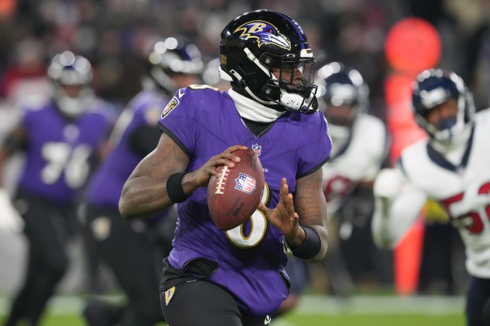 Baltimore Ravens quarterback Lamar Jackson (8) rolls out to throw against the Houston Texans during the second quarter of a 2024 AFC Divisional Round game at M&T Bank Stadium on January 20, 2024.