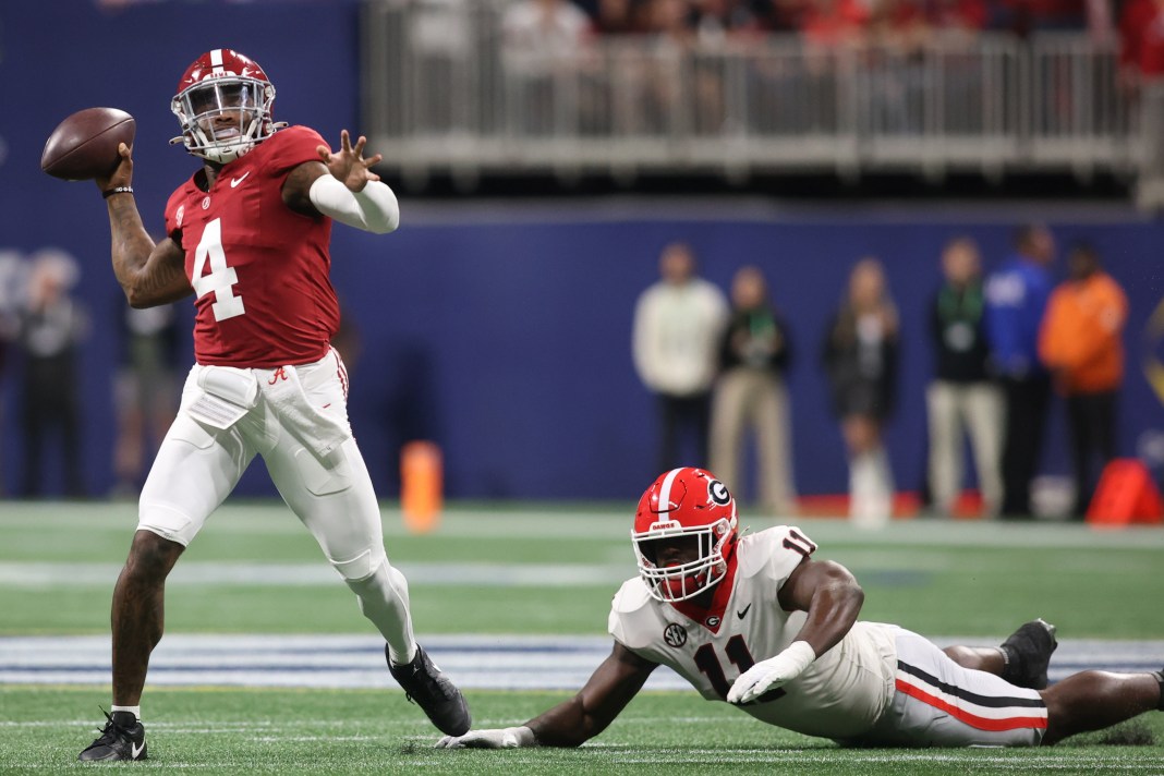 Alabama Crimson Tide quarterback Jalen Milroe (4) throws a pass while being defended by Georgia Bulldogs linebacker Jalon Walker (11) during the first half of the SEC Championship game at Mercedes-Benz Stadium on December 2, 2023.