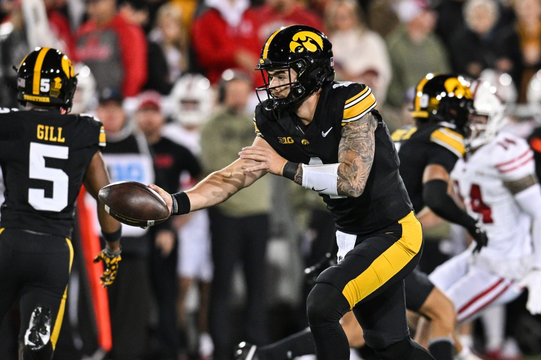 Iowa Hawkeyes quarterback Brendan Sullivan (1) hands the ball off against the Wisconsin Badgers during the first quarter at Kinnick Stadium