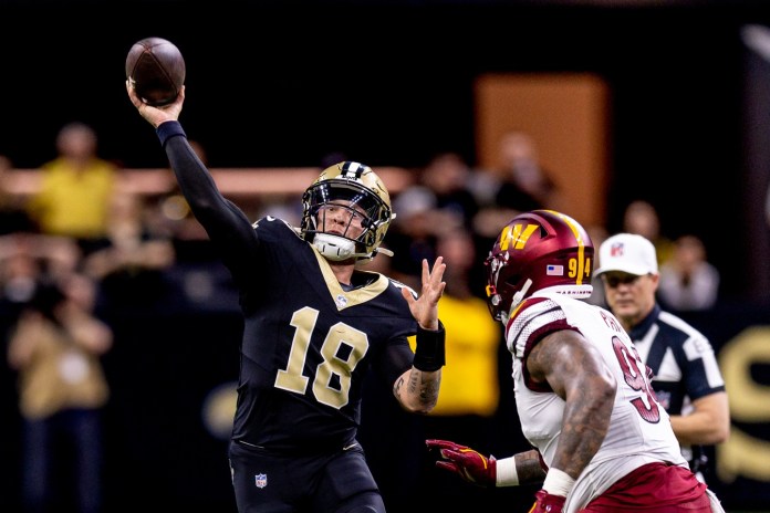 New Orleans Saints quarterback Spencer Rattler scrambles against Washington Commanders defensive tackle Daron Payn