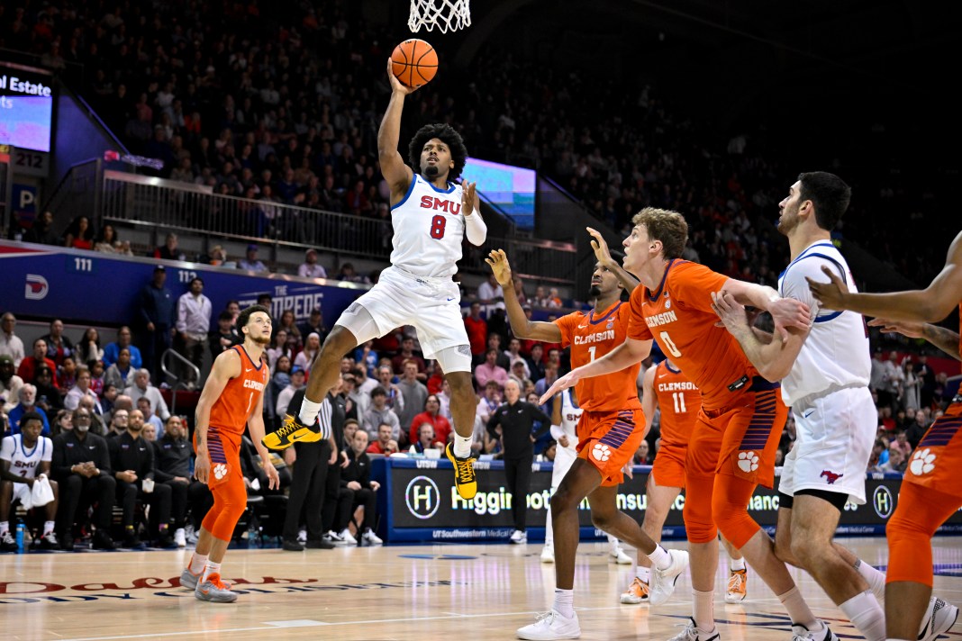 SMU Mustangs guard Kario Oquendo (8) shoots the ball as Clemson Tigers forward Chauncey Wiggins (7) and center Viktor Lakhin (0) look on during the second half at Moody Coliseum on February 22, 2025.