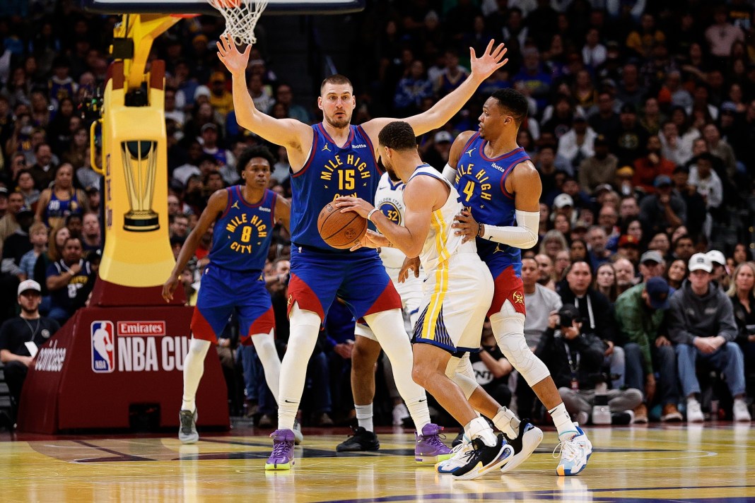 Golden State Warriors guard Stephen Curry (30) controls the ball under pressure from Denver Nuggets guard Russell Westbrook (4) and center Nikola Jokic (15) in the fourth quarter at Ball Arena on December 3, 2024.