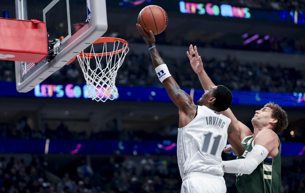 Dallas Mavericks guard Kyrie Irving (11) shoots past Milwaukee Bucks center Brook Lopez (11) during the first half at American Airlines Center on March 1, 2025.