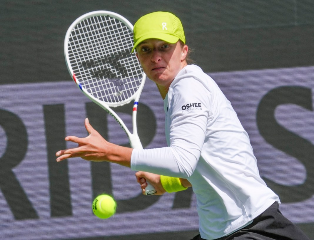 Iga Swiatek hits a forehand at the BNP Paribas Open in Indian Wells in 2025.