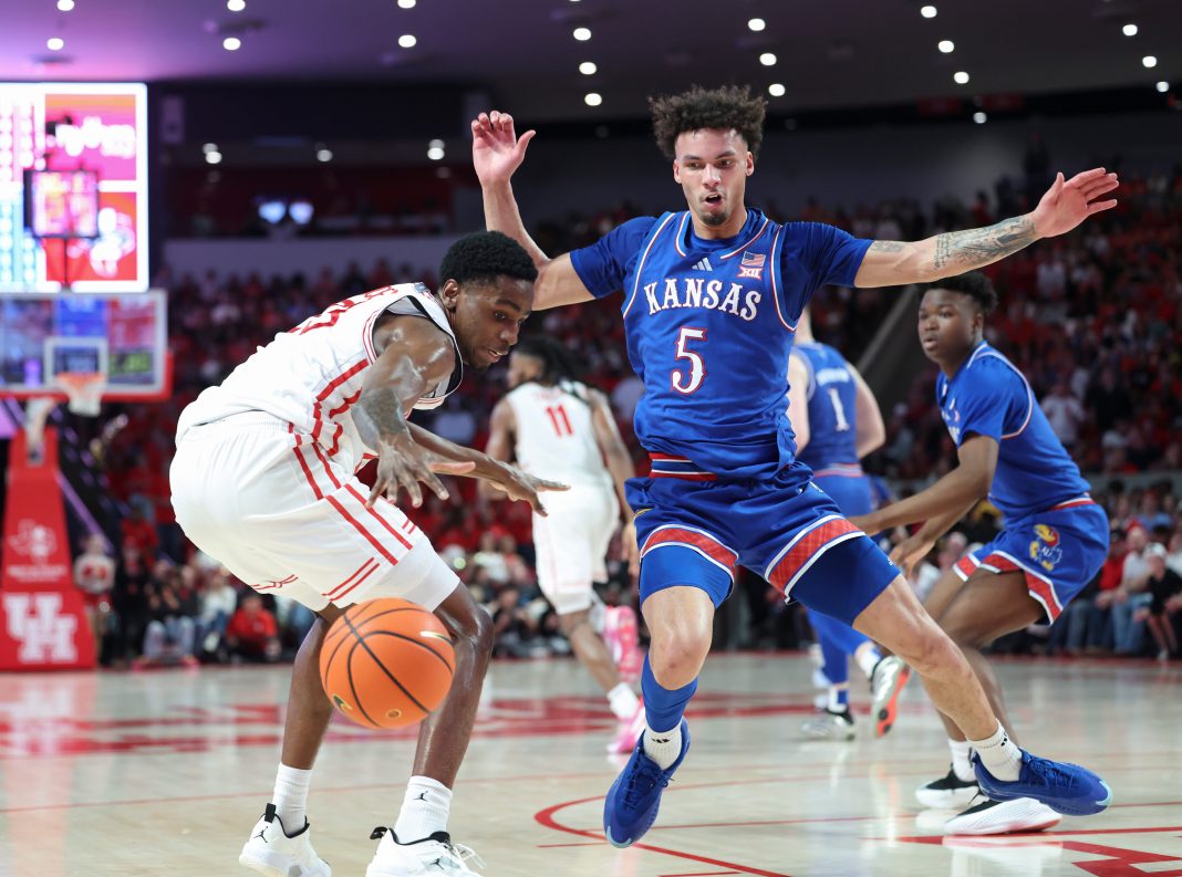 Houston Cougars guard Terrance Arceneaux (23) and Kansas Jayhawks guard Zeke Mayo (5) attempt to secure a loose ball during the first half at Fertitta Center on March 3, 2025.